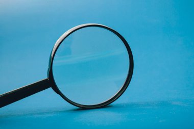 Mavi arka planda büyüteç. konsept arama