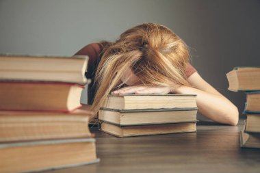 Genç bayan kitapların önünde otururken uyuyakaldı.