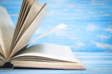 Mavi ahşap arkaplan üzerine açık kitap