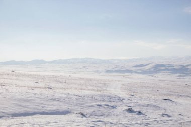 boş tarla ve karla kaplı tepeler