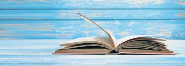 Mavi ahşap arkaplan üzerine açık kitap