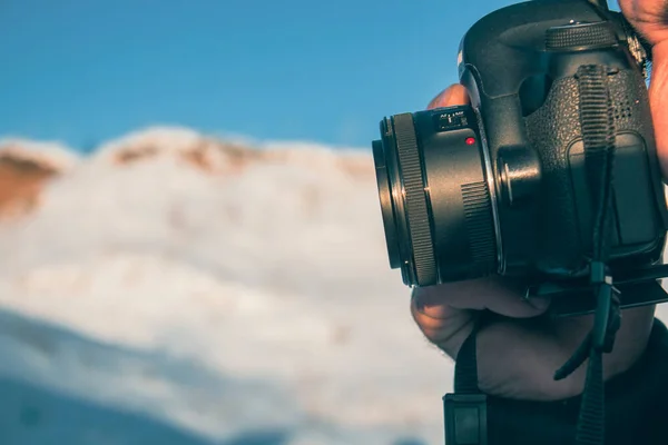 Een Man Die Een Camera Vasthoudt Een Achtergrond Van Sneeuw — Stockfoto