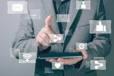 Sosyal ağlar için simgeler. Paylaşım, kablosuz ağ, bilgisayar. İş adamı ekrana basıyor ve telefonu tutuyor.