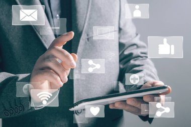 Sosyal ağlar için simgeler. Paylaşım, kablosuz ağ, bilgisayar. İş adamı ekrana basıyor ve elinde bir tablet tutuyor