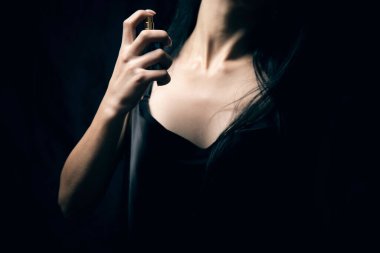 Kız kendine parfüm serpiyor.