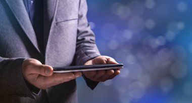 Bokeh arkaplanı üzerinde tablet tutuluyor