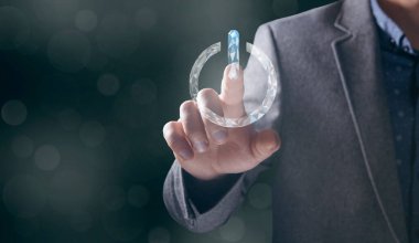 Bir adam ekrandaki sanal düğmeye basıyor.