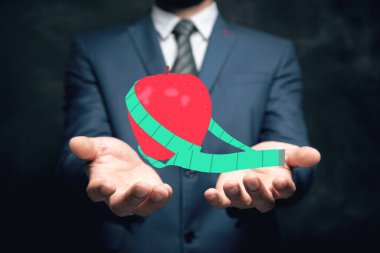 Elma ve mezura. diyet konsepti Adam elinde tutuyor.