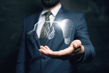 Resimli bir el bir ampule dokunur. Elinde tutan adam.