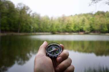 compass on the background of a forest lake