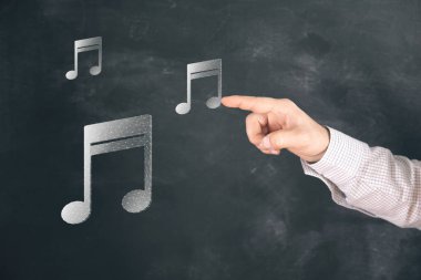 Web 'den müzik notası simgesi. Ekranda tıklayan adam