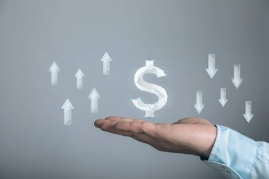 Ağdan bir dolar. Oklar yukarı ve aşağı. Elinde tutan adam.