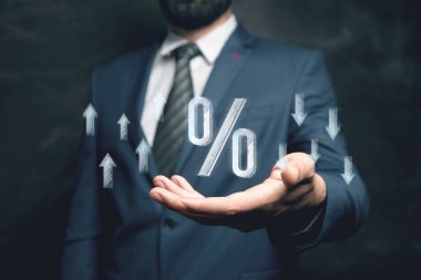 Yüzde simgesi ve internetten yukarı aşağı oklar. Elinde tutan adam.