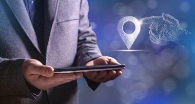 A hand from the network clicks on the GPS. Man holding a tablet in his hand