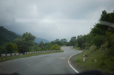 Asfalt yolu ormanlardan ve dağlardan geçer.
