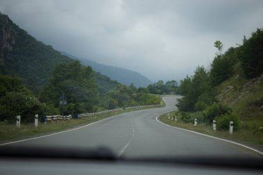 Asfalt yolu ormanlardan ve dağlardan geçer.