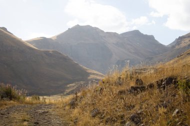 Dağların arasından geçen toprak yol.