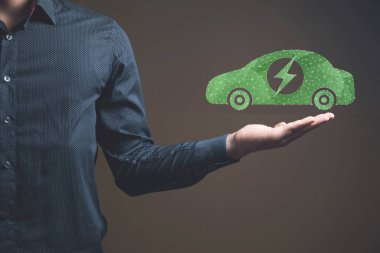 Şebekeden elektrikli araba. Elinde tutan adam.