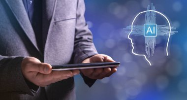 Baş siluetindeki ana kartta yapay zeka var. Elinde tablet tutan bir adam.