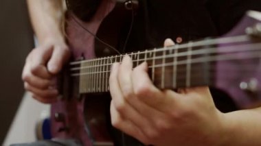 Bir müzisyenin çaldığı gitarın yakın çekimi.