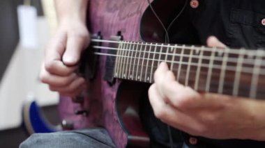 Bir müzisyenin çaldığı elektro gitarın yakın çekimi..