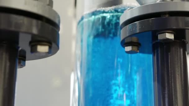 В прозрачной фляжке находится гейзер с голубой водой. — стоковое видео