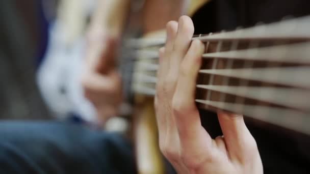 Zbliżenie gitarzystów palce przestawianie akordy na gitarze basowej podstrunnicy. — Wideo stockowe
