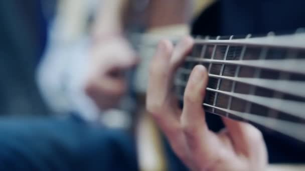 베이스 프리츠 보드에 있는 현들을 재배열하는 기타 연주자들의 집게손가락의 근접 사진. — 비디오