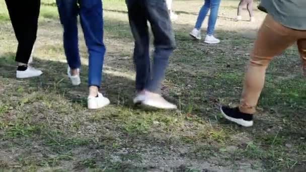 Ludzie tańczą synchronicznie na trawniku.. — Wideo stockowe