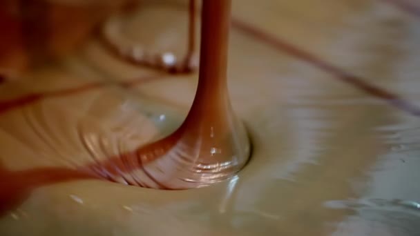 Hot chocolate flows down from above into a special hopper. — Stock Video