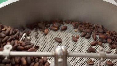 Kavrulmuş kahve çekirdekleri kızartma makinesinde karıştırılır..