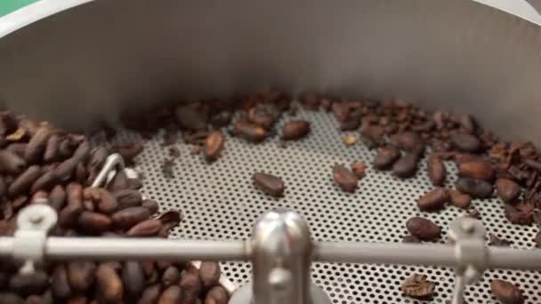 Los granos de café tostados se mezclan en una tostadora. — Vídeo de stock