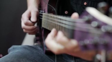 Bir müzisyenin çaldığı gitarın yakın çekimi.