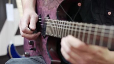 Gitar çalan bir müzisyenin yakın çekimi..