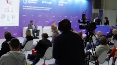 Bir kameraman konferans odasında hoparlörleri çekiyor..