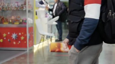 İsimsiz insanlar kendilerini çeken bir kameranın önünden geçiyorlar..