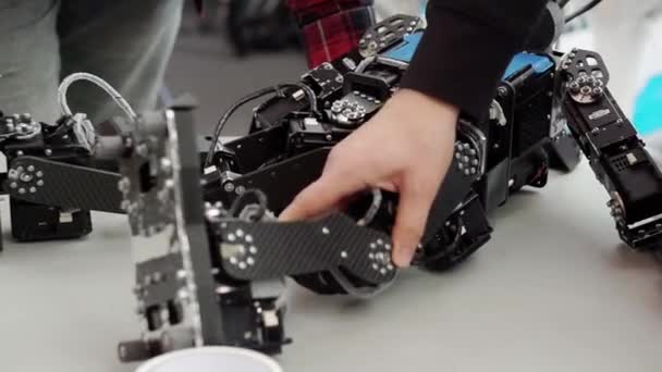 Un joven ingeniero inventor repara su robot. — Vídeo de stock
