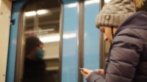 Egy nő egy metró kocsiban okostelefonnal. — Stock videók