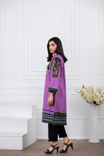 A Pakistani shalwar kameez suit with dupatta. Pakistani model is shown her dress with style.