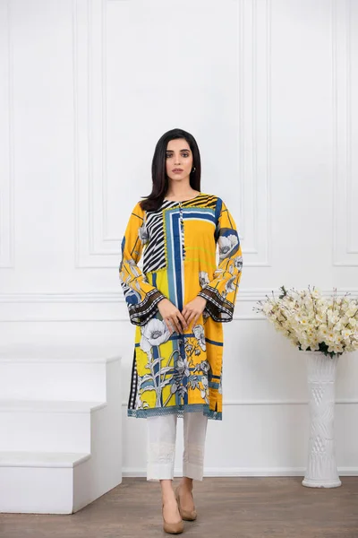 A Pakistani shalwar kameez suit with dupatta. Pakistani model is shown her dress with style.
