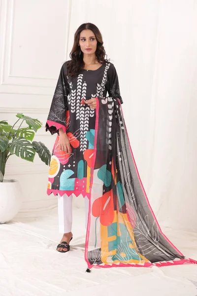 A Pakistani shalwar kameez suit with dupatta. Pakistani model is shown her dress with style.