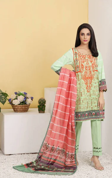 A Pakistani shalwar kameez suit with dupatta. Pakistani model is shown her dress with style.