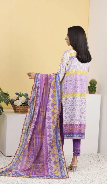 A Pakistani shalwar kameez suit with dupatta. Pakistani model is shown her dress with style.