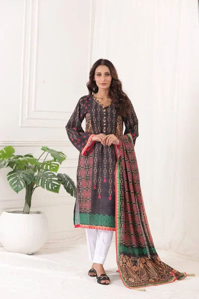 A Pakistani shalwar kameez suit with dupatta. Pakistani model is shown her dress with style. Indian dress.