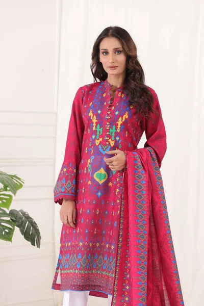 A Pakistani shalwar kameez suit with dupatta. Pakistani model is shown her dress with style. Indian dress.