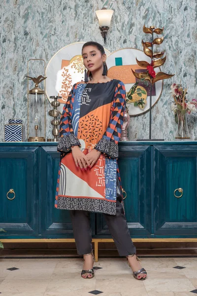 A Pakistani shalwar kameez suit with dupatta. Pakistani model is shown her dress with style.