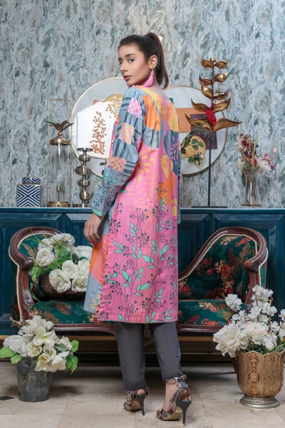 A Pakistani shalwar kameez suit with dupatta. Pakistani model is shown her dress with style.