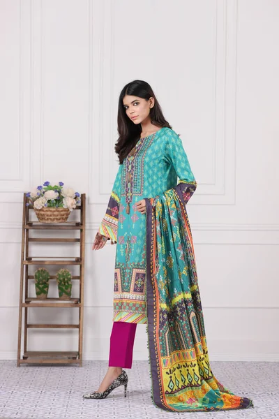 A Pakistani shalwar kameez suit with dupatta. Pakistani model is shown her dress with style.