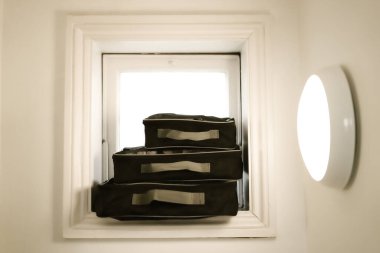 Bir şeyleri saklamak için küçük çantalar birbirinin üstünde duruyor. Aynı çantalar, farklı boyutlarda. Siyah çantalar beyaz arka planda üst üste yatar..