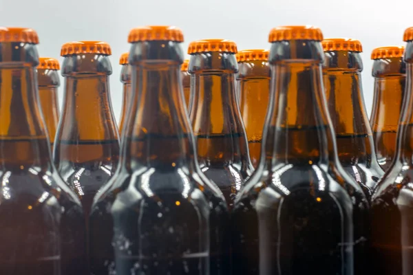 白を基調としたラベルのない自家製ビール オレンジキャップ付きのビールボトルのクローズアップ写真 オレンジキャップ付きの分離ビールボトル — ストック写真
